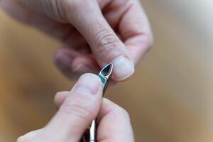 vrouwen handen Doen manicures door trimmen nagelriemen met nagel tondeuse foto