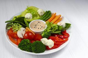 groente salade van tomaten wortels, klok paprika's met saus eetpatroon voedsel keto eetpatroon foto
