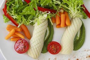 gekookt inktvis met baby wortels en sla, tomaten en erwt puree. keto eetpatroon. foto