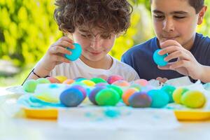twee gelukkig jongens spelen met kleurrijk Pasen eieren foto