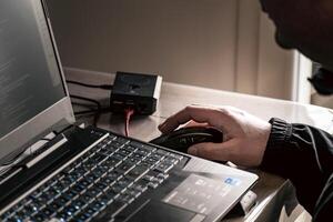 dichtbij omhoog van man's hand- gebruik makend van draadloze muis en laptop computer met blauw verlicht toetsenbord foto