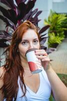 latina vrouw drinken een kop van koffie buiten in de tuin. foto