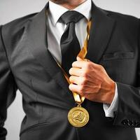 ai gegenereerd zakenman Holding een goud medaille in zwart pak. foto