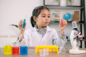 Aziatisch kind meisje aan het leren wetenschap chemie met test buis maken experiment Bij school- laboratorium. opleiding, wetenschap, chemie, en kinderen concepten. vroeg ontwikkeling van kinderen. foto