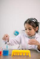 Aziatisch kind meisje aan het leren wetenschap chemie met test buis maken experiment Bij school- laboratorium. opleiding, wetenschap, chemie, en kinderen concepten. vroeg ontwikkeling van kinderen. foto
