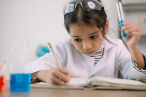 Aziatisch kind meisje aan het leren wetenschap chemie met test buis maken experiment Bij school- laboratorium. opleiding, wetenschap, chemie, en kinderen concepten. vroeg ontwikkeling van kinderen. foto