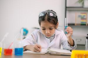 Aziatisch kind meisje aan het leren wetenschap chemie met test buis maken experiment Bij school- laboratorium. opleiding, wetenschap, chemie, en kinderen concepten. vroeg ontwikkeling van kinderen. foto