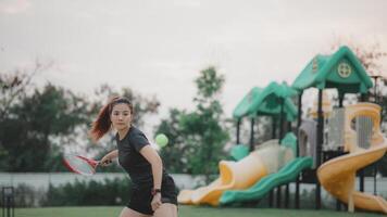 een vrouw is spelen tennis in een park foto