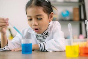 Aziatisch kind meisje aan het leren wetenschap chemie met test buis maken experiment Bij school- laboratorium. opleiding, wetenschap, chemie, en kinderen concepten. vroeg ontwikkeling van kinderen. foto