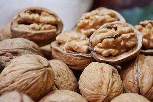 een lepel van walnoten, een superfood, rust Aan een stack van noten zaden foto