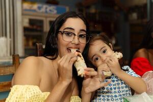 moeder en dochter aan het eten baleada's. traditioneel voedsel concept. foto