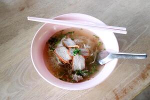 Thais stijl noodle met rood rooster varkensvlees met lepel en eetstokje foto