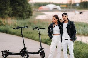 portret van een paar zittend in de buurt elektrisch scooters, genieten van tijd in natuur samen, twee geliefden Aan elektrisch scooters.mensen Aan scooters foto