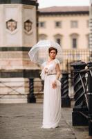 een mooi elegant bruid met een paraplu wandelingen door de oud stad van florence.model met paraplu's in Italië.Toscane. foto