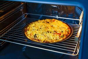 pizza met kaas Aan een ronde dienblad in een oven. horizontaal visie. foto