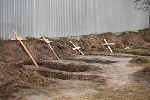 bucha, Oekraïne - april 12, 2022 leeg graven van de gedood door de Russisch leger burgers, begraven door hun buren in huis tuin, na opgraving van hun lichamen foto