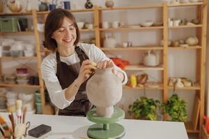 professioneel vrouw keramist werk met ongevuurd klei vaas in pottenbakkerij studio. hoog kwaliteit foto