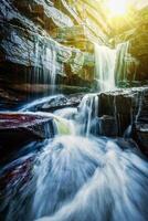 tropisch waterval met zon stralen foto