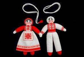 ai gegenereerd twee martenitsa poppen in traditioneel Russisch kleding zijn Aan een zwart achtergrond foto