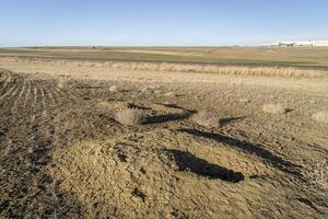 vroeg voorjaar landschap van noordelijk Colorado uitlopers met prairie hond holen, landbouwgrond, spoorweg, en industrieel gebouw foto