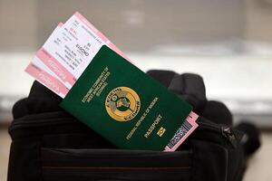 groen Nigeriaans paspoort met vliegmaatschappij kaartjes Aan toeristisch rugzak foto