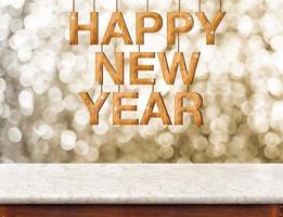 gelukkig nieuwjaar houtstructuur met fonkelende ster hangen op marmeren tafel met sprankelende gouden bokeh muur foto