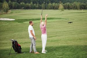 groep stijlvolle vrienden op de golfbaan leren een nieuw spel te spelen foto