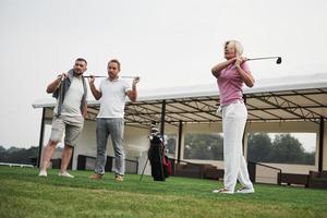 groep stijlvolle vrienden op de golfbaan leren een nieuw spel te spelen