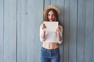 het papier in de handen houden. uitstekende jonge meisjesglimlachen op de camera foto