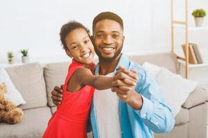 knap vader en schattig dochter dansen Bij huis foto