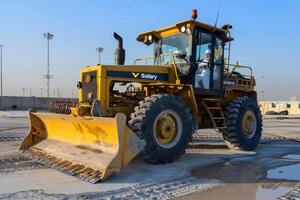 groomer in de midden- oosten. grader geparkeerd Aan beton platen Bij een industrieel complex foto