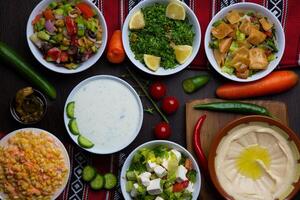 geassorteerd hummus, raita, dik, mutabal, quinoa salade, tussendoortje geserveerd in schotel geïsoleerd Aan tafel top visie van Arabisch voedsel foto