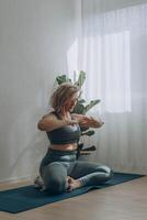 een 50 jaar oud vrouw doet yoga Bij huis foto