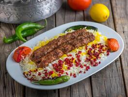 chelo kebab biryani geserveerd in schotel kant visie Aan houten tafel achtergrond foto