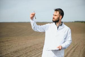 agronoom aan het studeren monsters van bodem in veld- foto