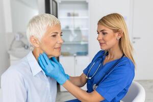 endocrinoloog onderzoeken keel van senior vrouw in kliniek. Dames met schildklier klier test . endocrinologie, hormonen en behandeling. ontsteking van de zeer keel foto