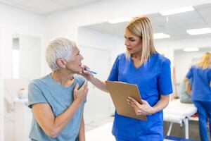 vrouw dokter osteopaat in medisch uniform vaststelling senior vrouw patiënten schouder en terug gewrichten in handleiding behandeling kliniek gedurende op bezoek komen. professioneel osteopaat gedurende werk met geduldig concept foto