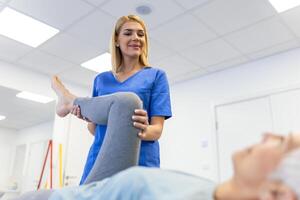 professioneel chiropractor of fysiotherapeut helpt naar genezen een senior vrouw rug. dokter reparaties de geduldig aan het liegen Aan een bankstel van een modern revalidatie kliniek concept van fysiek revalidatie. foto