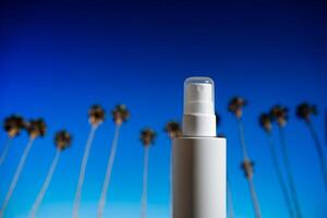 blanco zonnescherm fles tegen blauw lucht en palm bomen foto