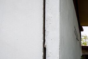 gebarsten beton muur gebroken muur Bij de buiten cement hoek dat uitgevoerd met aardbeving en ingestort grond foto