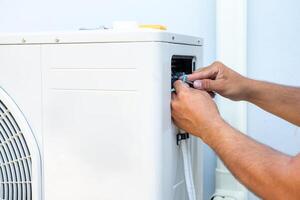 mannetje technicus installeren buitenshuis eenheid van lucht conditioner naar koel de huishouden in de zomer. lucht compressor, elektronisch, foto