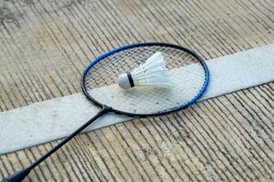 badminton racket en wit shuttle geplaatst Aan cement achtergrond. zacht en selectief focus. foto