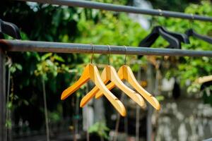 houten kleren hanger met een natuurlijk bladerrijk achtergrond in de tuin foto