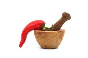 rood Chili peper en houten stamper met Mortier foto