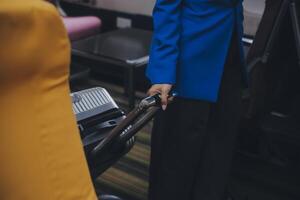 Aziatisch vrouw reiziger zetten bagage in overhead kastje Aan vliegtuig gedurende instappen. foto