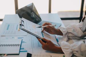 co werken conferentie, bedrijf team vergadering Cadeau, investeerder uitvoerend collega's bespreken nieuw plan financieel diagram gegevens Aan buitenshuis kantoor tafel met laptop en tablet, financiën, accounting foto