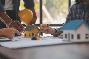 een team van bouw ingenieurs praat naar managers en bouw arbeiders Bij de bouw plaats. kwaliteit inspectie, werk plan, huis en industrieel gebouw ontwerp project foto