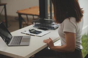 schot van een Aziatisch jong bedrijf vrouw werken Aan laptop in haar werkstation. foto