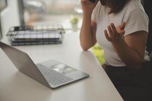 jong volwassen gelukkig glimlachen spaans Aziatisch leerling vervelend hoofdtelefoons pratend Aan online babbelen vergadering gebruik makend van laptop in Universiteit campus of Bij virtueel kantoor. college vrouw leerling aan het leren van een afstand. foto