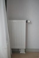 wit radiator Aan grijs wit muur. appartement verwarming installatie systeem, foto